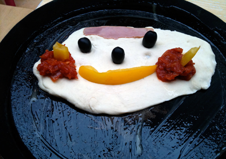 Una carita feliz formada por alimentos en un sartén